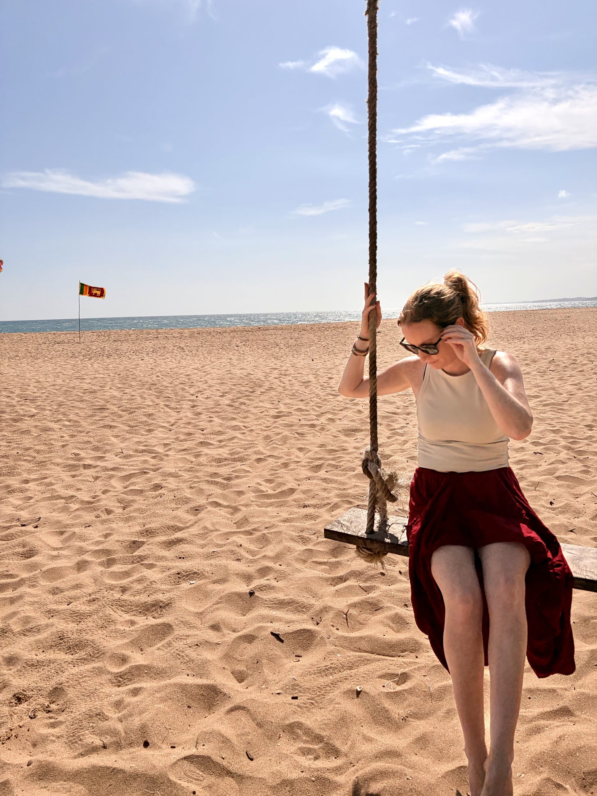 Young female sitting on a swing alone on beach in Tangalle, Sri lanka