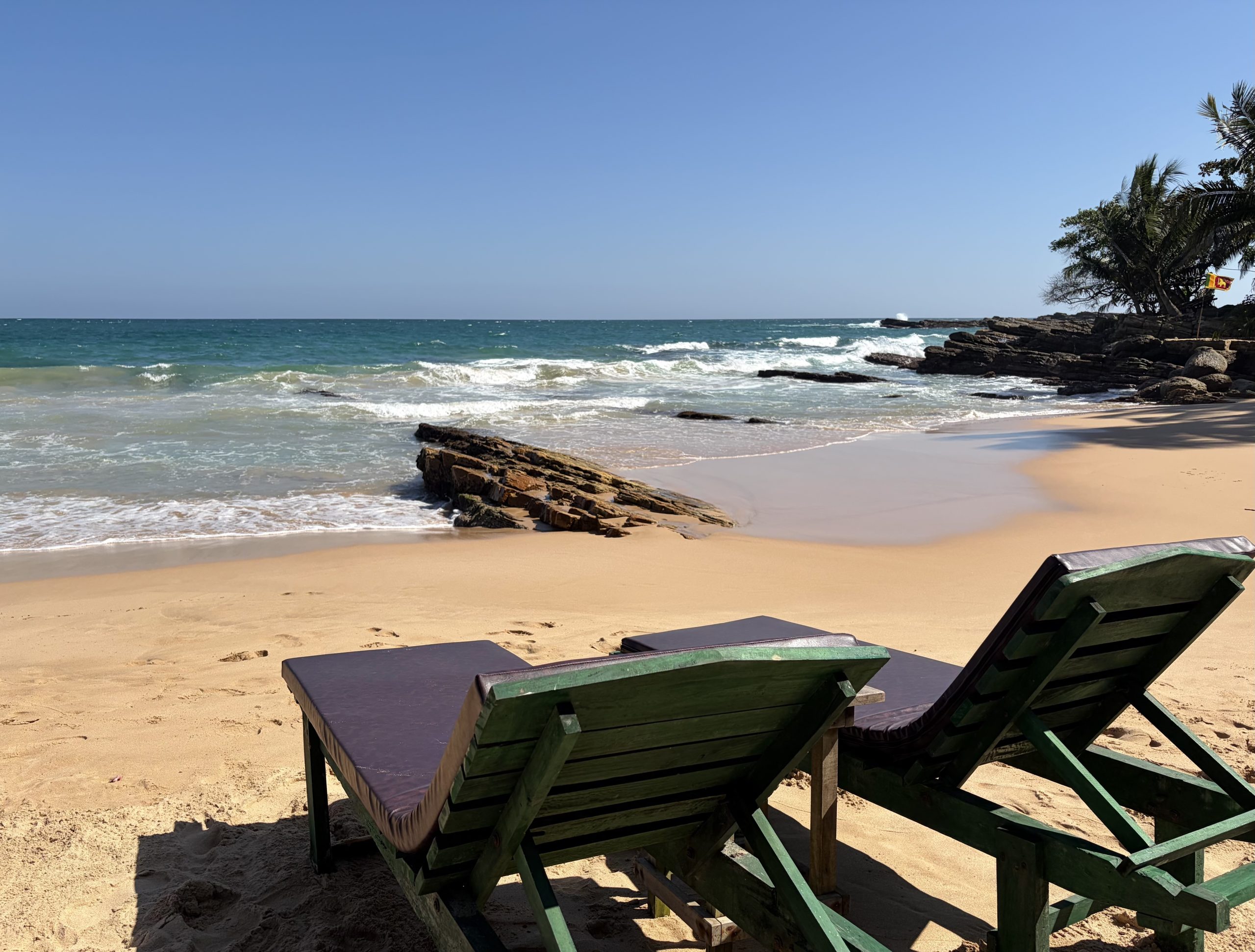 Two empty sunloungers on empty beach in Tangalle, Sri Lanka